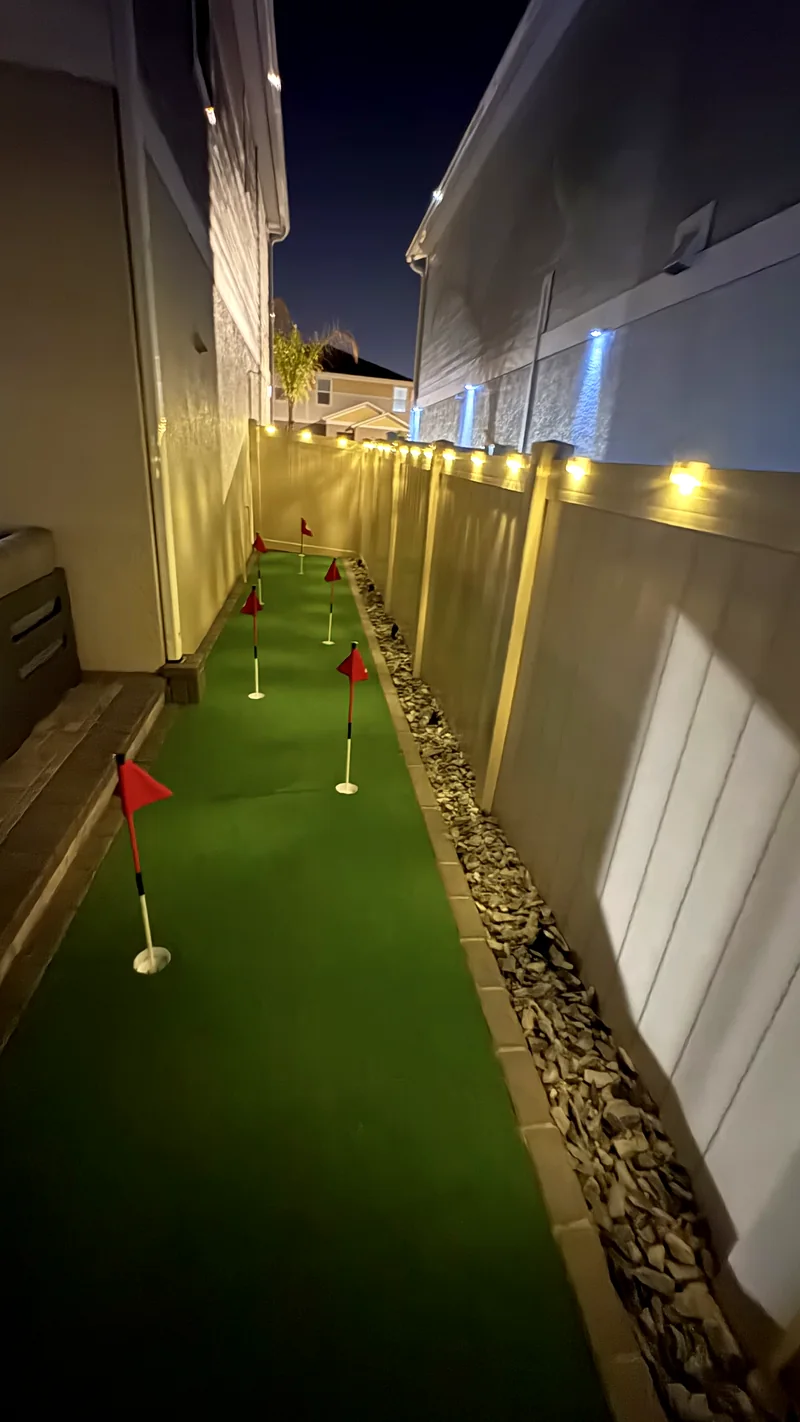 Putting green built into the side yard, lit for night play
